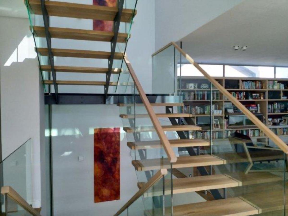 Dark steel staircase with dramatic natural light by Sterianos
